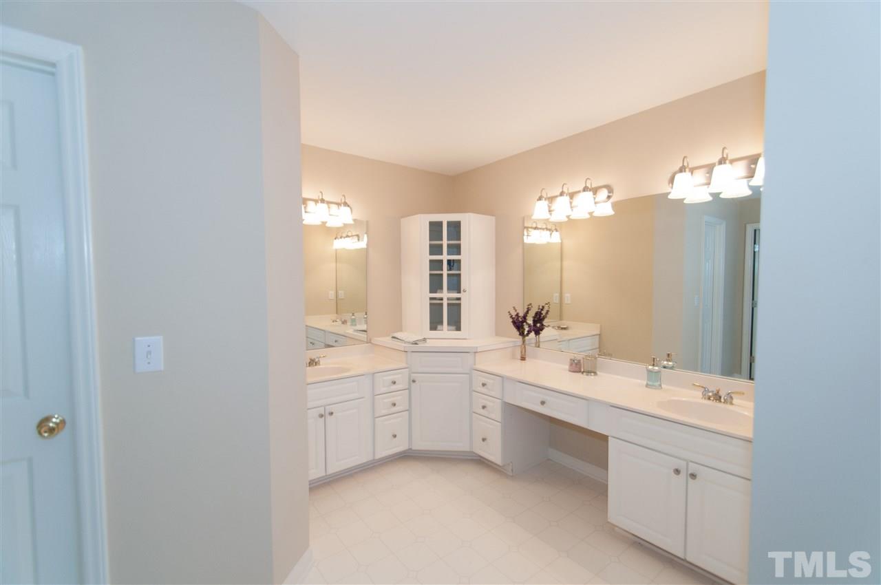 8905 Braceridge Road Raleigh, NC 27613 - Photo 15 of 25 a bathroom with a double vanity sink a mirror and a bathtub