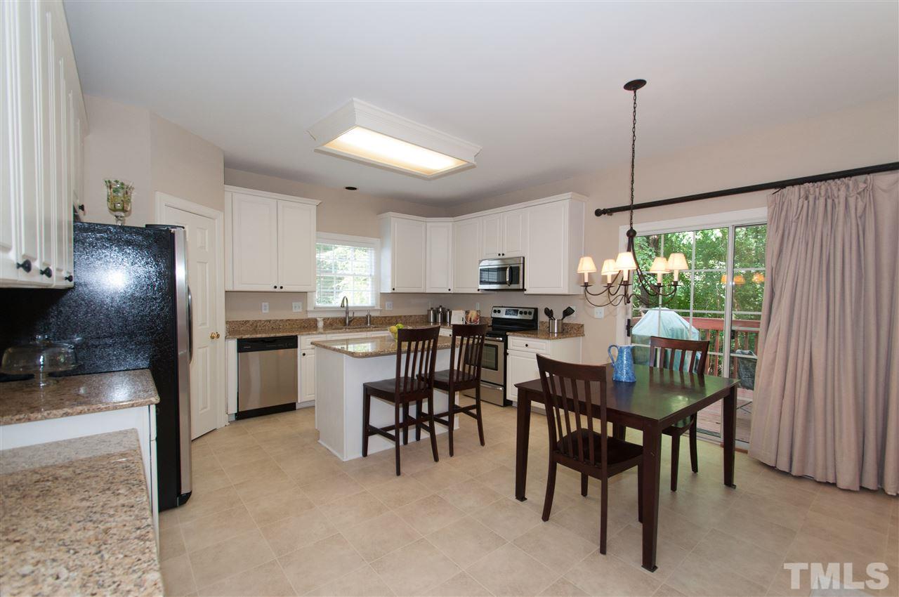 8905 Braceridge Road Raleigh, NC 27613 - Photo 4 of 25 a kitchen with kitchen island a dining table chairs stainless steel appliances and cabinets