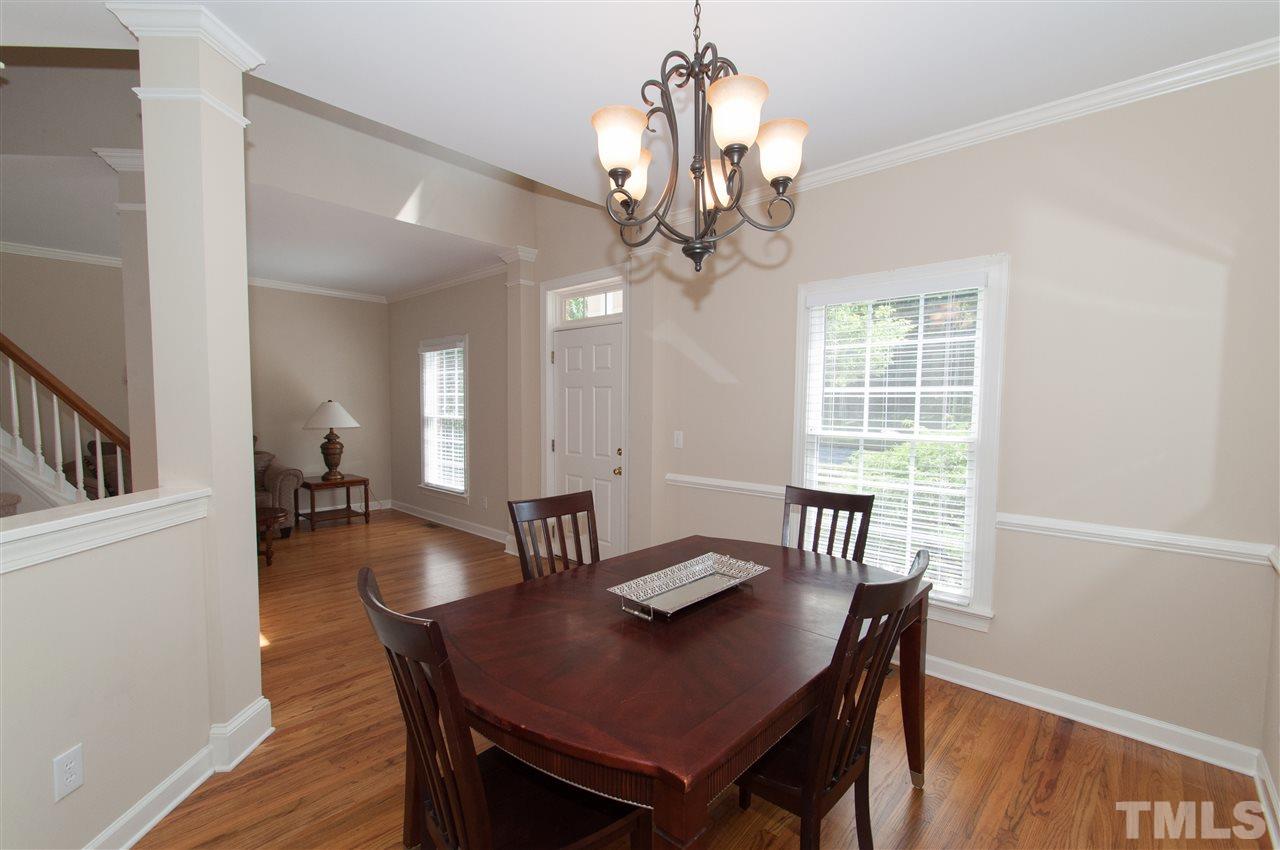 8905 Braceridge Road Raleigh, NC 27613 - Photo 9 of 25 a view of a dining room with furniture a chandelier and wooden floor