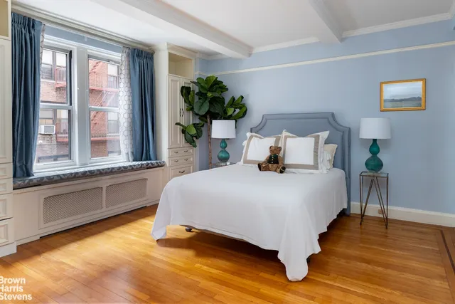 a bedroom with a bed lamp and a large window