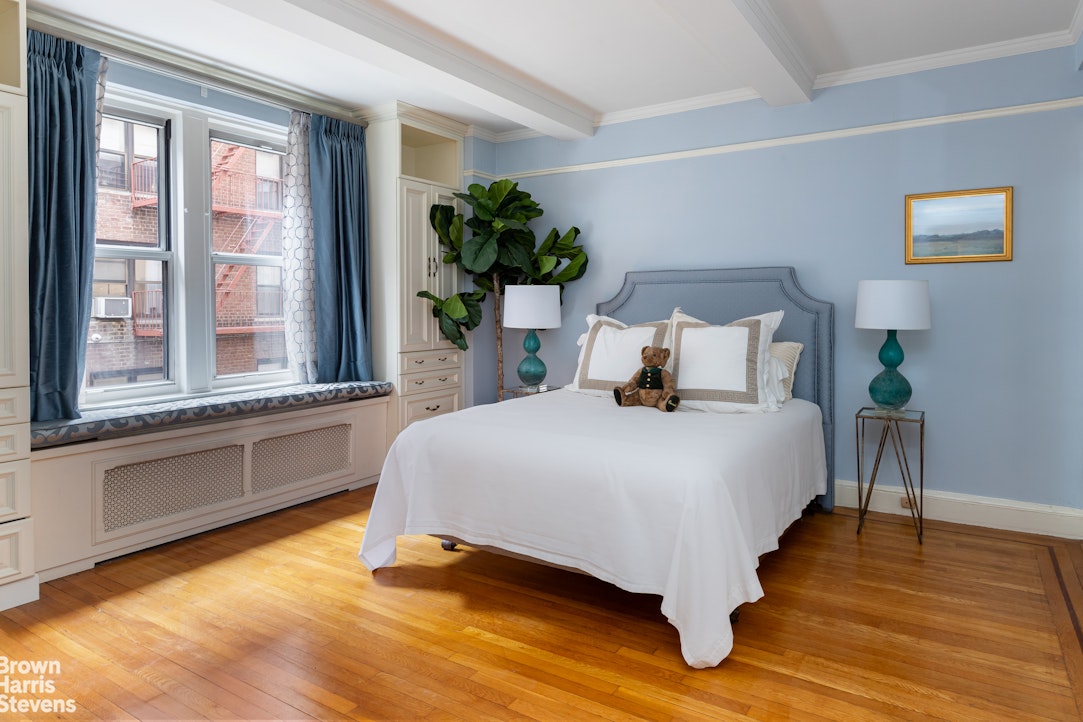 325 East 79th Street, Unit 3E Manhattan, NY 10075 - Photo 3 of 14 a bedroom with a bed lamp and a large window