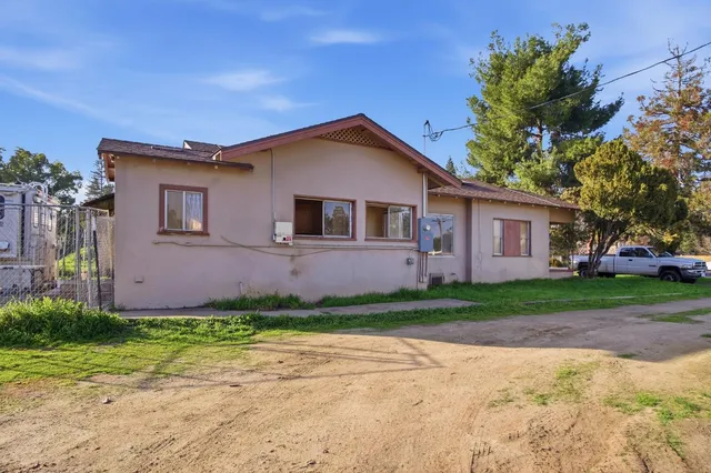 a front view of a house with a garden and trees