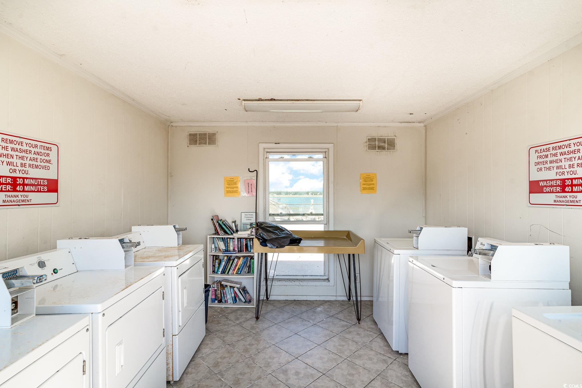 1582 South Waccamaw Drive, Unit 60 Murrells Inlet, SC 29576 - Photo 17 of 24 Clothes washing area featuring wooden walls, crown molding, separate washer and dryer, and light tile patterned floors