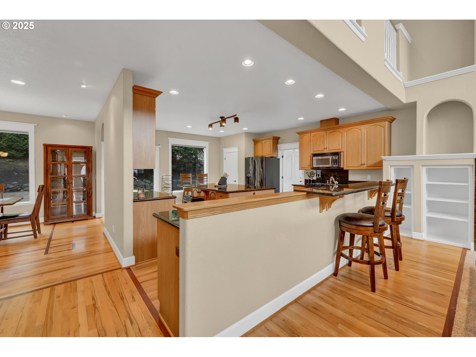 2375 Lasater Boulevard Eugene, OR 97405 - Photo 9 of 46 a kitchen with stainless steel appliances kitchen island granite countertop a refrigerator a stove a sink a dining table and chairs with wooden floor