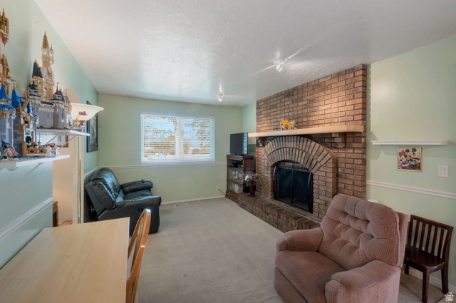 11072 Windy Peak Ridge Drive, Unit 32 Sandy, UT 84094 - Photo 10 of 30 Spacious room featuring a prominent brick fireplace with an arched firebox and a wood mantel