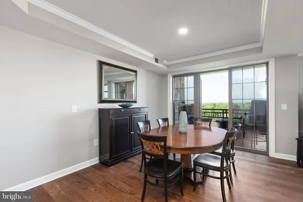 a hallway with white cabinets and wooden floor