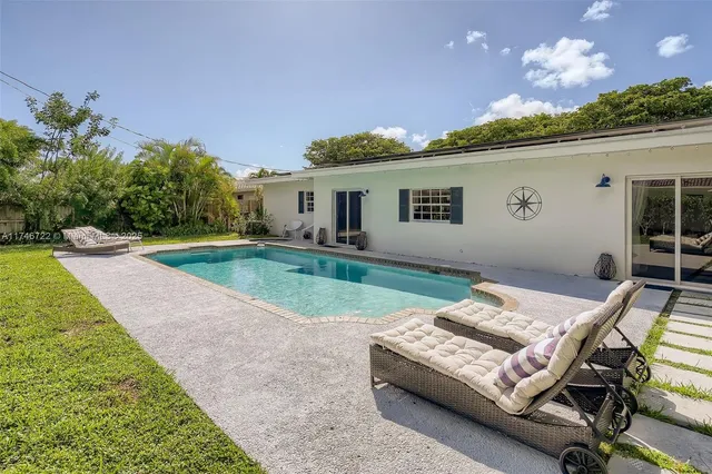 a view of a house with backyard and sitting area