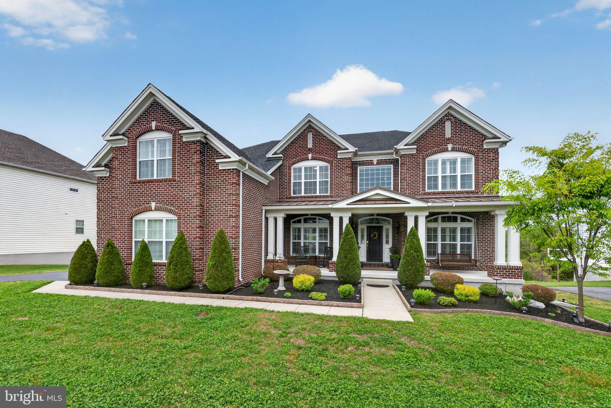 a front view of a house with yard and green space
