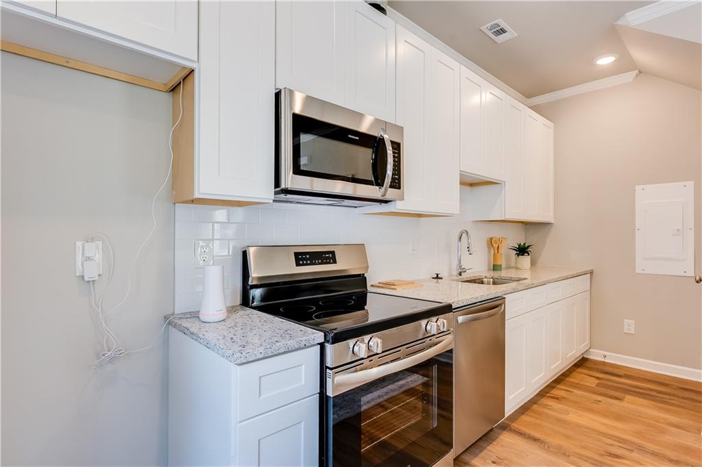 962 Lawton Street Southwest Atlanta, GA 30310 - Photo 6 of 14 a kitchen with a stove and a microwave
