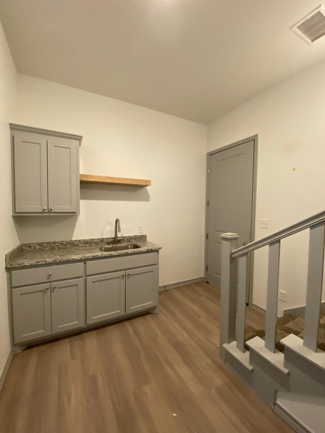 21402 County Road 2140 Lubbock, TX 79423 - Photo 9 of 23 a kitchen with granite countertop a sink and a stove top oven