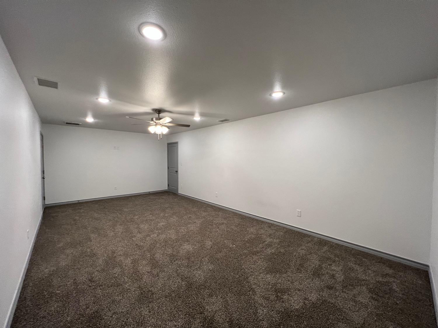 21402 County Road 2140 Lubbock, TX 79423 - Photo 10 of 23 an empty room with a ceiling fan and a window