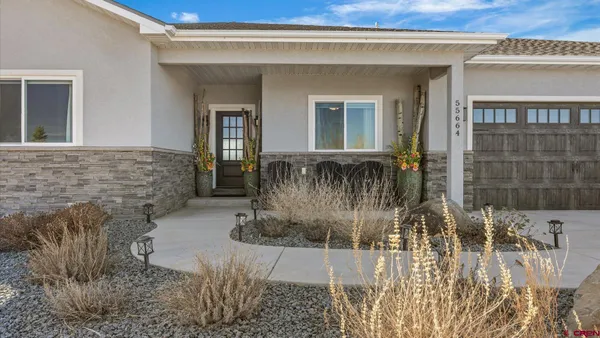 a kitchen with stainless steel appliances granite countertop a table chairs in it and wooden floors