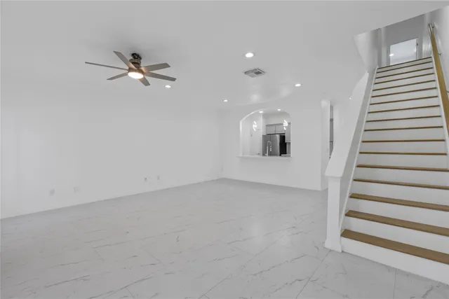 wooden floor in an empty room with a ceiling fan