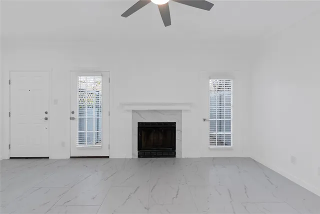 an empty room with windows fireplace and cabinet