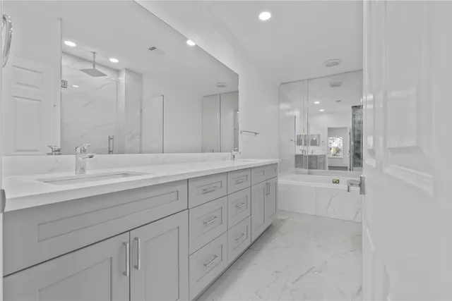a spacious bathroom with a granite countertop sink a toilet a mirror and shower