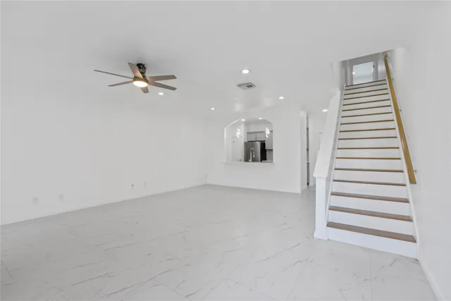 an empty room with windows and white walls