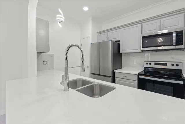 a kitchen with stainless steel appliances a sink a stove and microwave