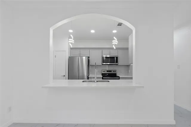 a kitchen with stainless steel appliances a refrigerator and a stove top oven