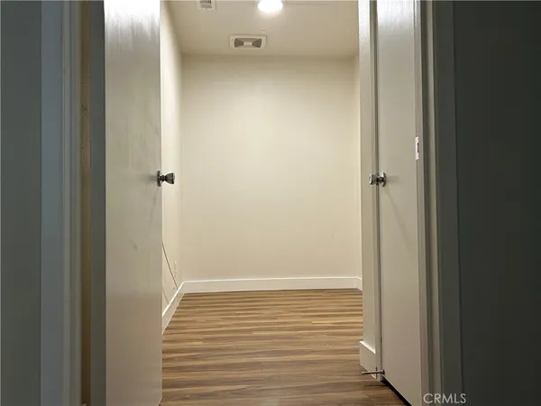a view of a room with wooden floor and a ceiling fan