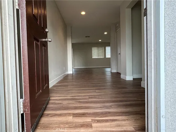 a view of a hallway with wooden floor