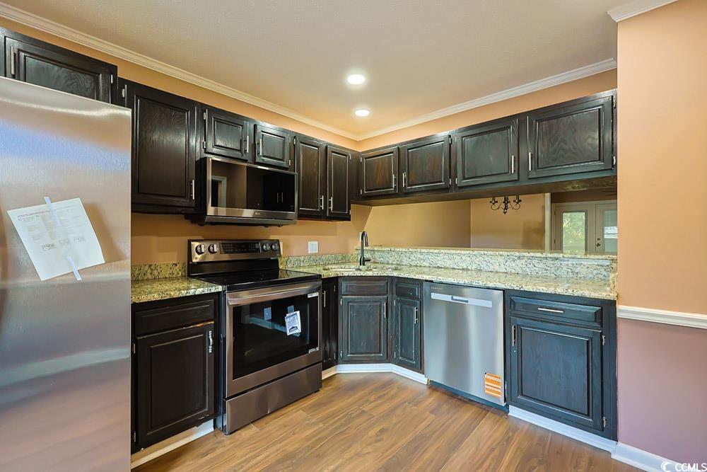 4840 Moss Creek Loop, Unit 3 Murrells Inlet, SC 29576 - Photo 6 of 40 Kitchen featuring stainless steel appliances, ornamental molding, light stone countertops, dark wood-style floors, and recessed lighting