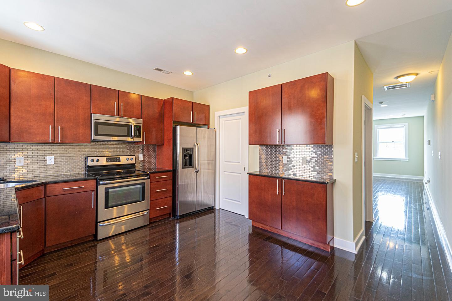 a kitchen with stainless steel appliances granite countertop wooden cabinets a stove top oven a sink and dishwasher