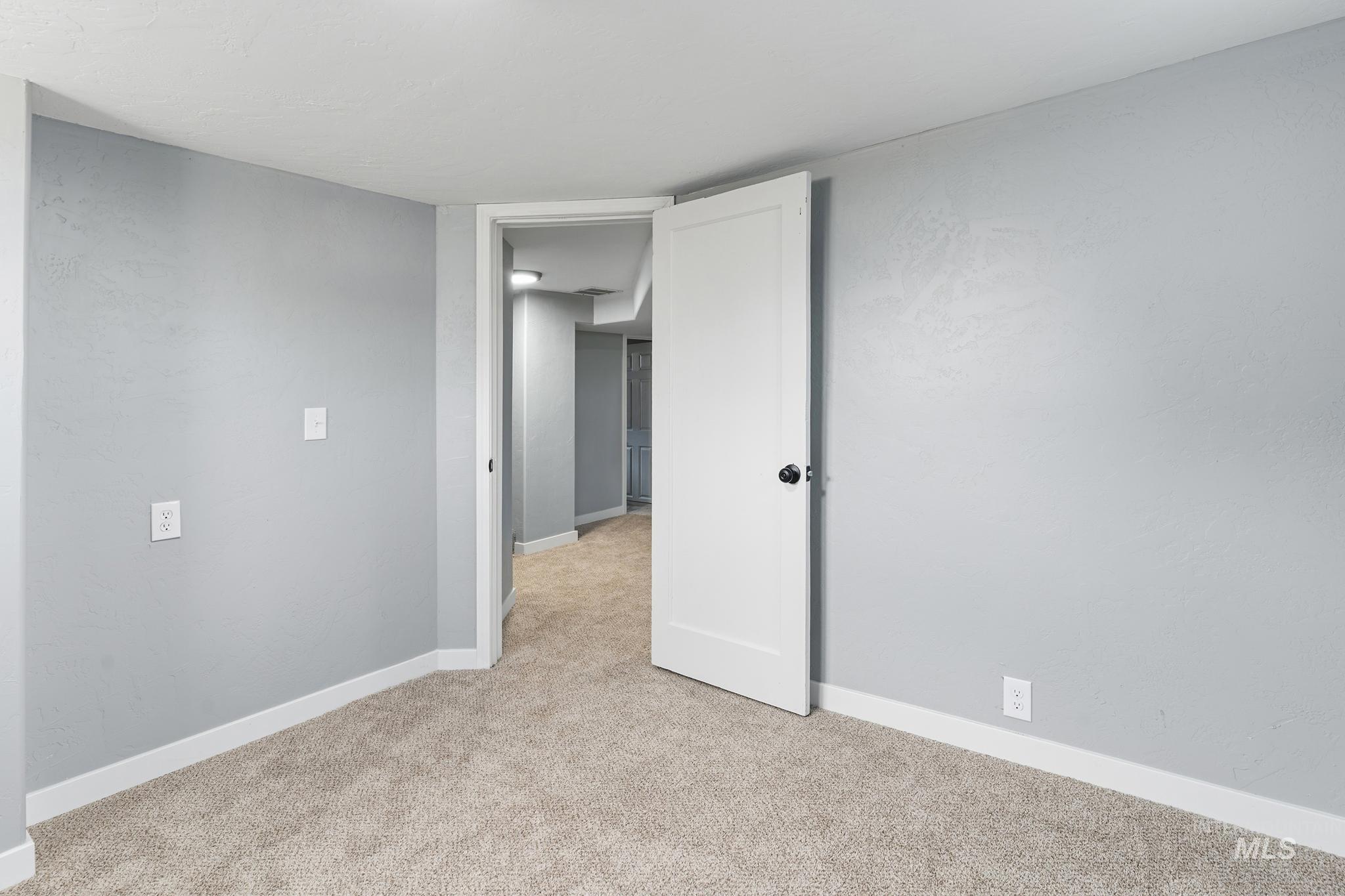 619 Thain Road Lewiston, ID 83501 - Photo 18 of 44 Spacious room featuring light gray walls, white trim, and neutral carpet flooring