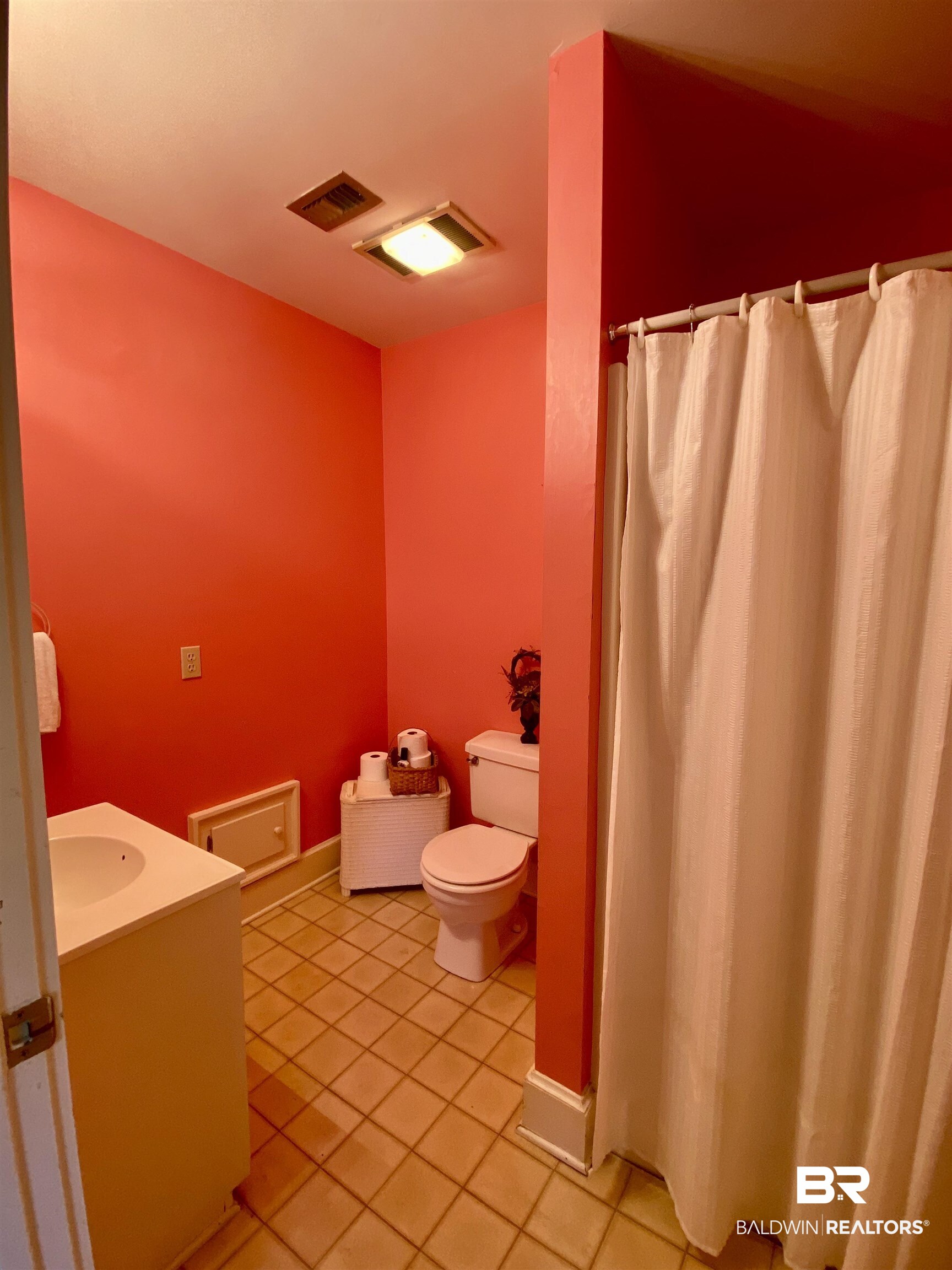 272 Longleaf Circle Monroeville, AL 36460 - Photo 14 of 38 Bathroom with vanity, tile patterned flooring, toilet, and curtained shower, adjacent to the laundry room.