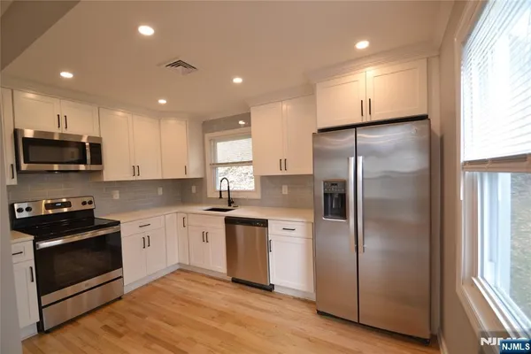 a kitchen with a refrigerator and a stove top oven