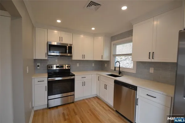 a kitchen with stainless steel appliances granite countertop a sink and a stove