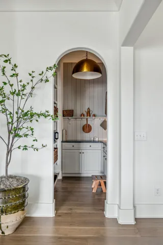 a room with a wooden floor and white cabinets