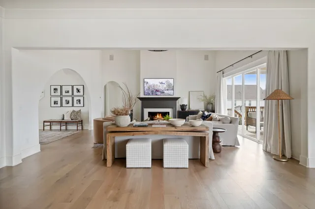 a living room with furniture a fireplace and wooden floor