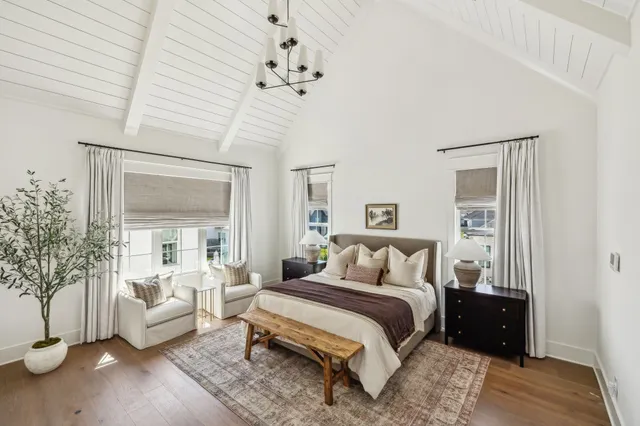 a bedroom with a large bed and a chandelier