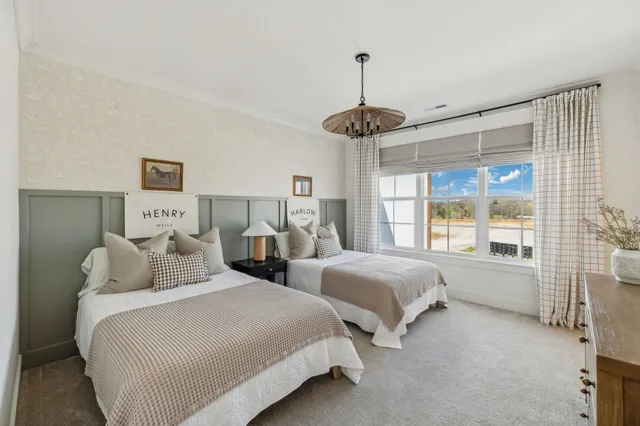 a bedroom with two large bed and a chandelier