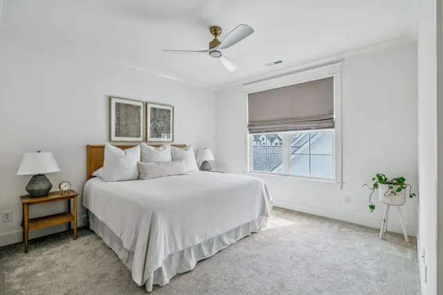 a spacious bedroom with a bed and a potted plant