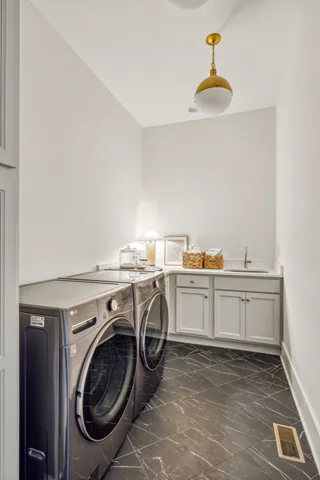 a utility room with sink dryer and washer