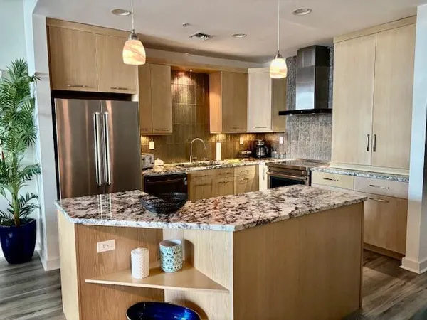 a kitchen with stainless steel appliances granite countertop a sink stove and refrigerator