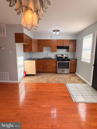a large kitchen with stainless steel appliances granite countertop a stove and a wooden floors