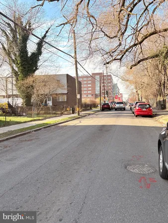 a view of a street with a cars parked on the road