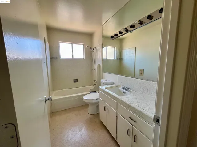 a bathroom with a double vanity sink toilet mirror and shower