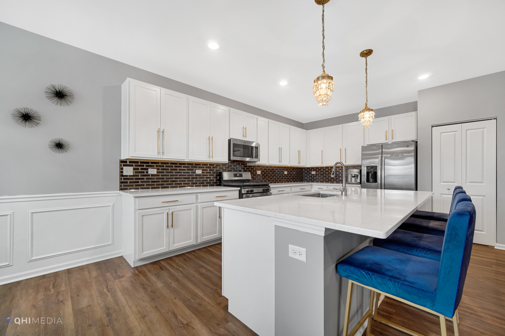 16017 Longcommon Lane Plainfield, IL 60586 - Photo 7 of 22 a kitchen with stainless steel appliances kitchen island granite countertop a sink a stove a refrigerator and white cabinets with wooden floor
