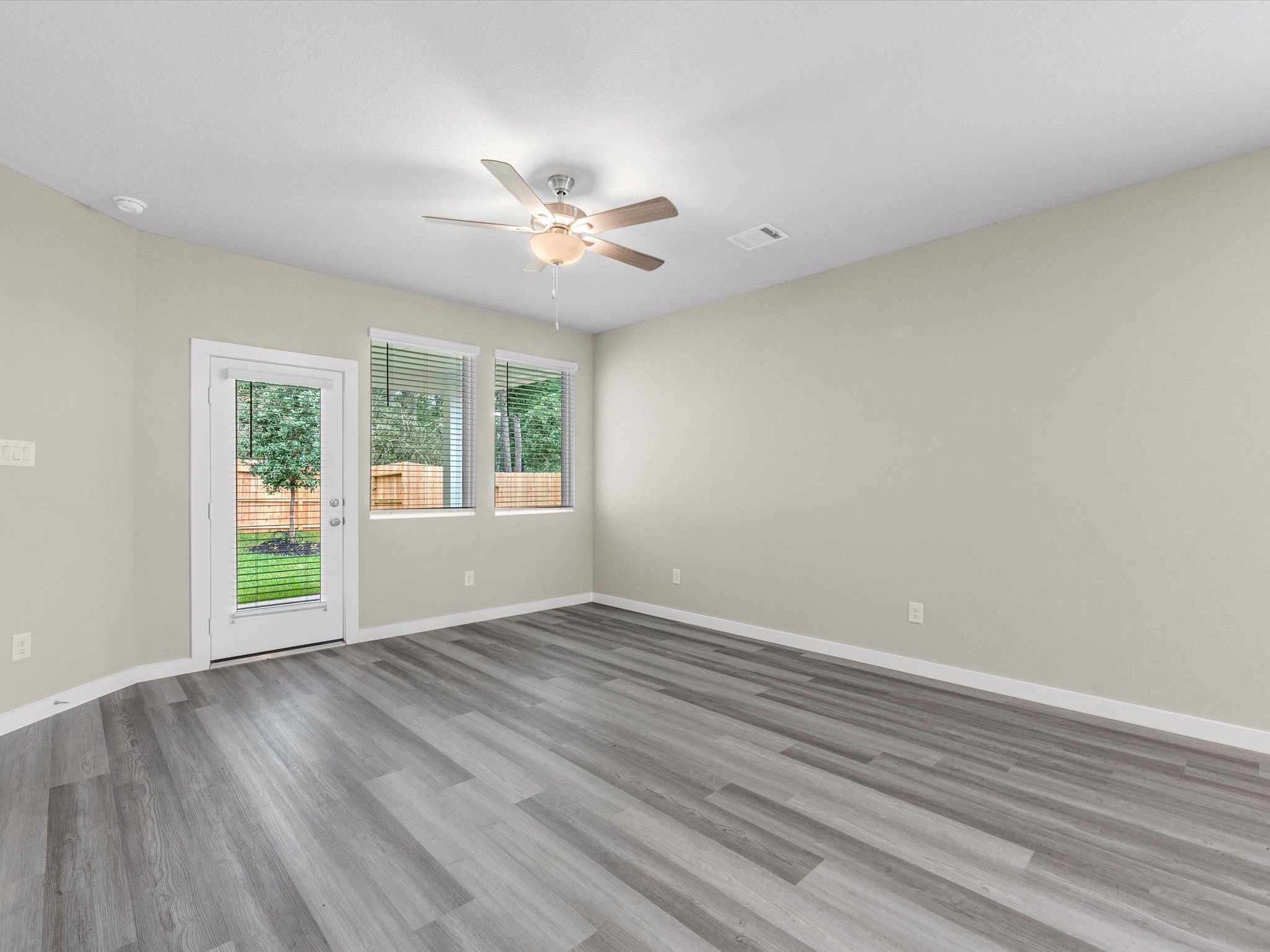 1749 Succotash Oak Court Conroe, TX 77304 - Photo 5 of 21 a view of an empty room with a window and wooden floor
