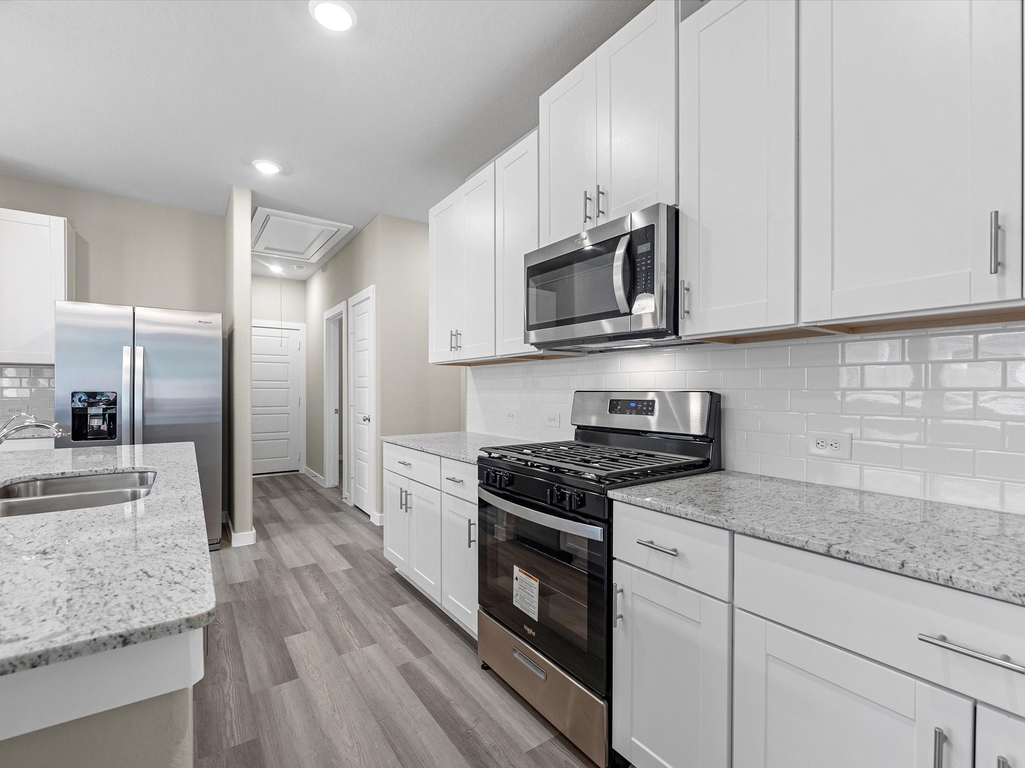 1749 Succotash Oak Court Conroe, TX 77304 - Photo 8 of 21 a kitchen with stainless steel appliances granite countertop a stove a sink and a microwave