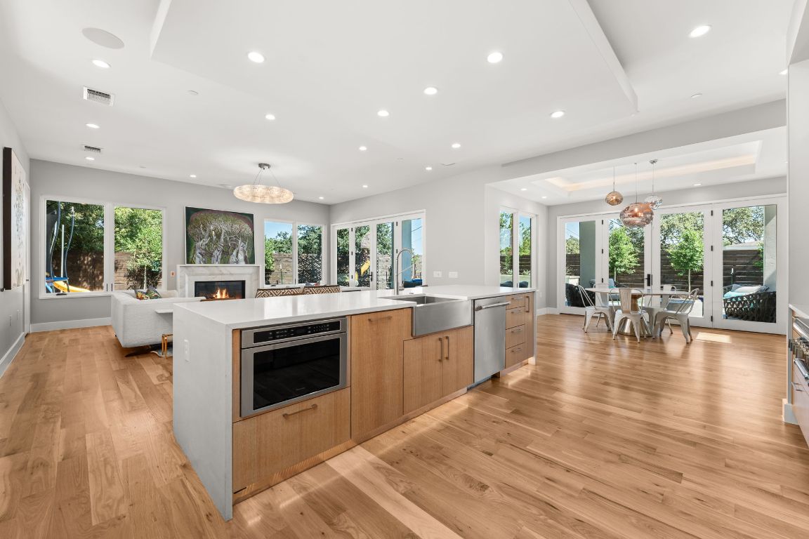4908 Beverly Skyline Austin, TX 78731 - Photo 13 of 40 Kitchen featuring hanging light fixtures, light brown cabinets, stainless steel appliances, light stone countertops, and light wood-type flooring