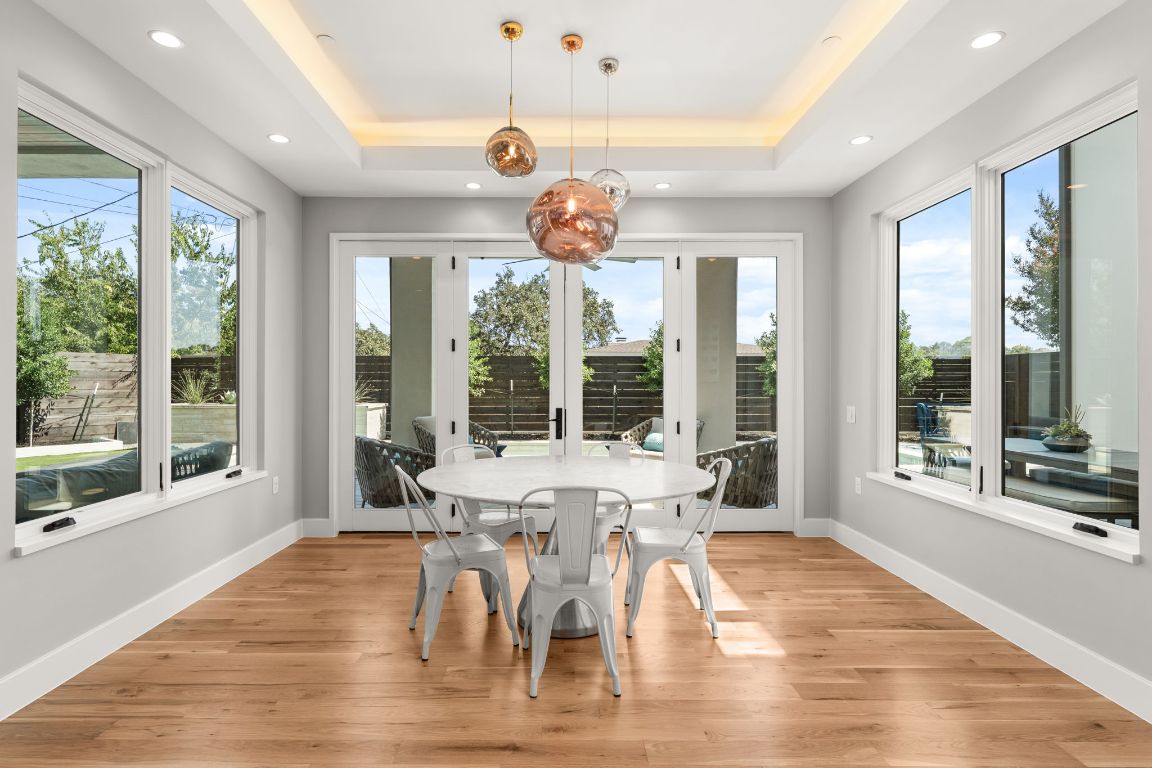 4908 Beverly Skyline Austin, TX 78731 - Photo 14 of 40 Sunroom featuring wood finished floors, healthy amount of natural light, a tray ceiling, and recessed lighting
