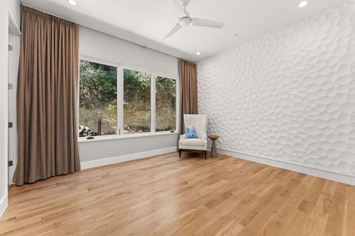 4908 Beverly Skyline Austin, TX 78731 - Photo 16 of 40 Unfurnished room with an accent wall, light wood-style flooring, recessed lighting, and ceiling fan