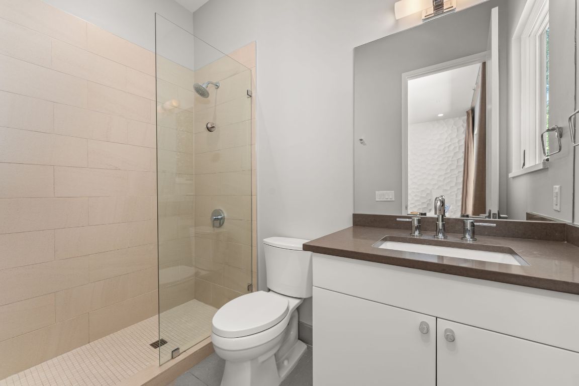 4908 Beverly Skyline Austin, TX 78731 - Photo 23 of 40 Full bathroom with a walk in shower, vanity, and tile patterned floors