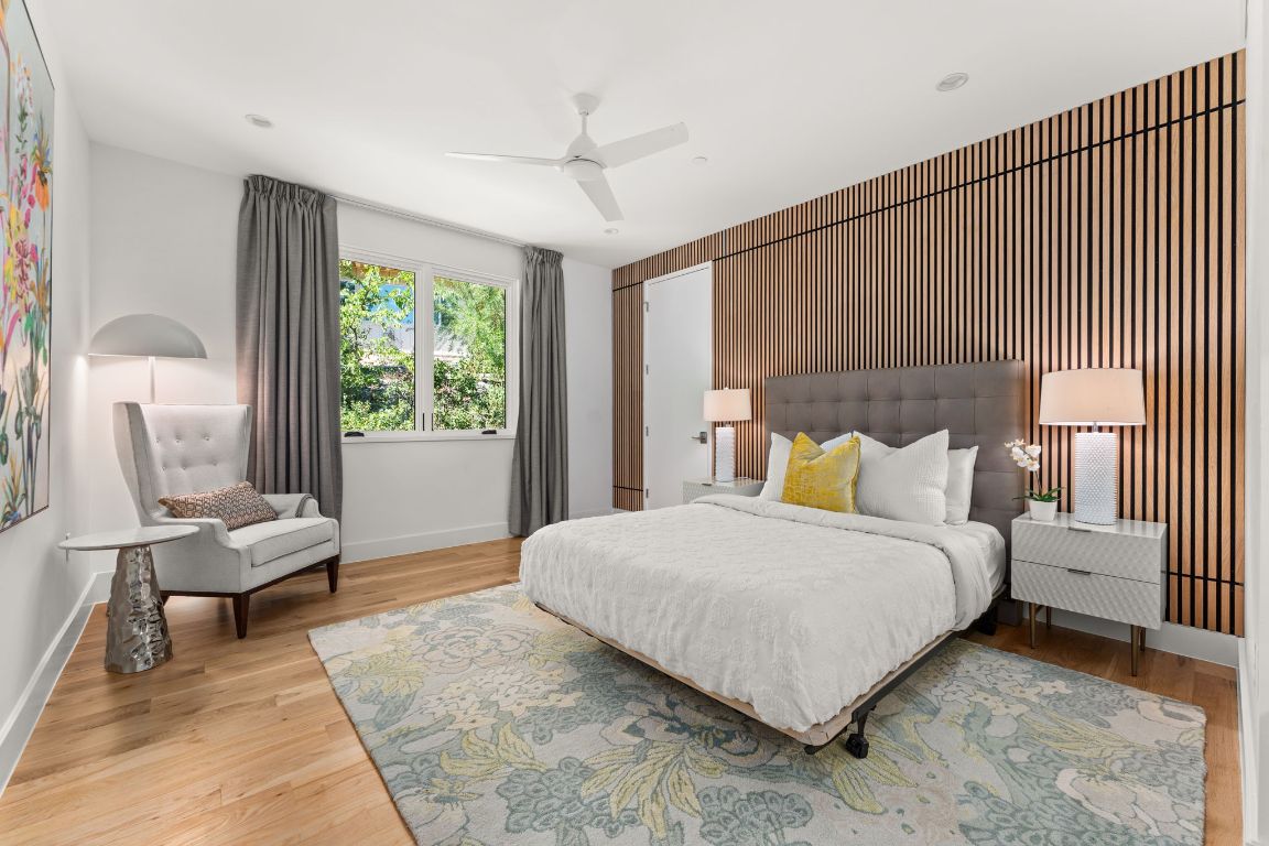 4908 Beverly Skyline Austin, TX 78731 - Photo 25 of 40 Bedroom with ceiling fan, an accent wall, light wood-type flooring, and wooden walls