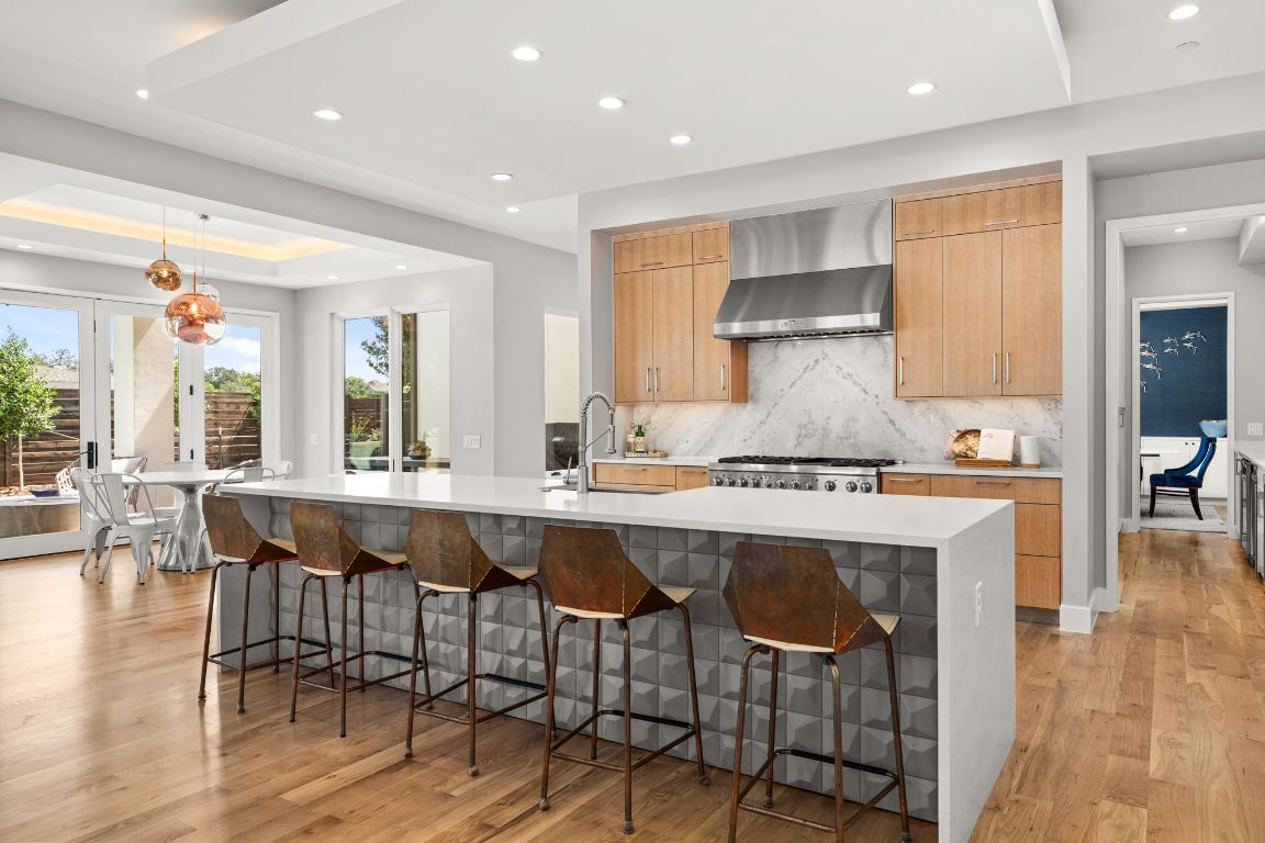 4908 Beverly Skyline Austin, TX 78731 - Photo 10 of 40 Kitchen featuring light stone countertops, decorative light fixtures, a breakfast bar area, recessed lighting, and light wood finished floors