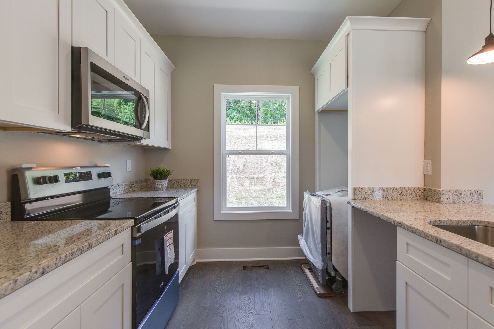 1026 Sycamore Ridge East, Unit 44 Burns, TN 37029 - Photo 17 of 28 a kitchen with granite countertop a sink stove and cabinets